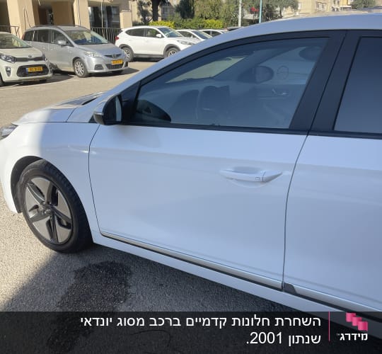 מכונית לבנה עם חלון כהה בחניה